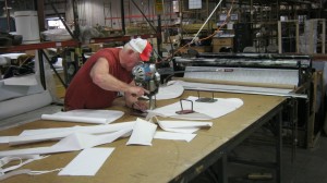 Charles cuts a small order of Accord non-woven fabric for a bag which will be used to hold fiber in a upholstered back.